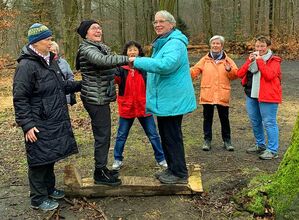 Wandergruppe bei gymnastischen Übungen im Wald