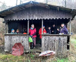 Wandergruppe macht Pause in Holzhütte