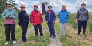 Personengruppe vor Skulptur